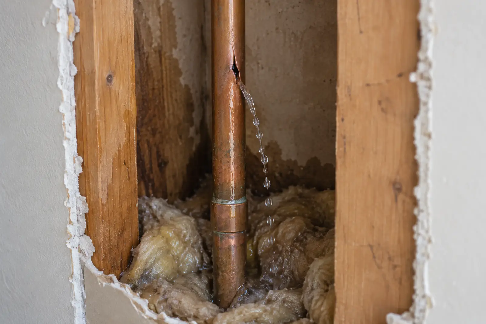Split water pipe leaking inside an open wall
